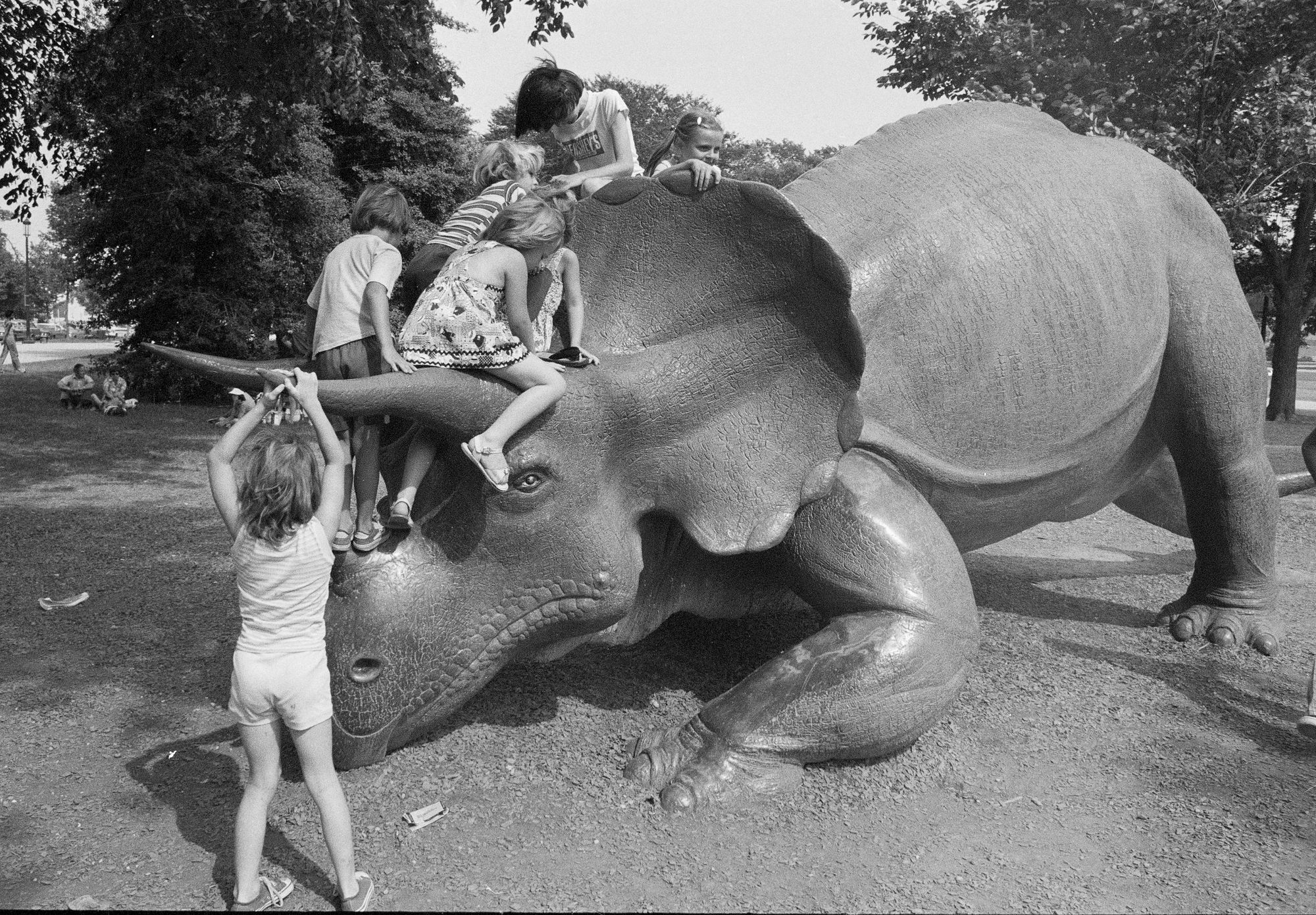 "Record Unit 95, Box 33, Folder 23"; "Six children play on the sculpture "Uncle Beazley," the 25 foot long replica of a triceratops, placed on the Mall in front of the National Museum of Natural History (NMNH)."